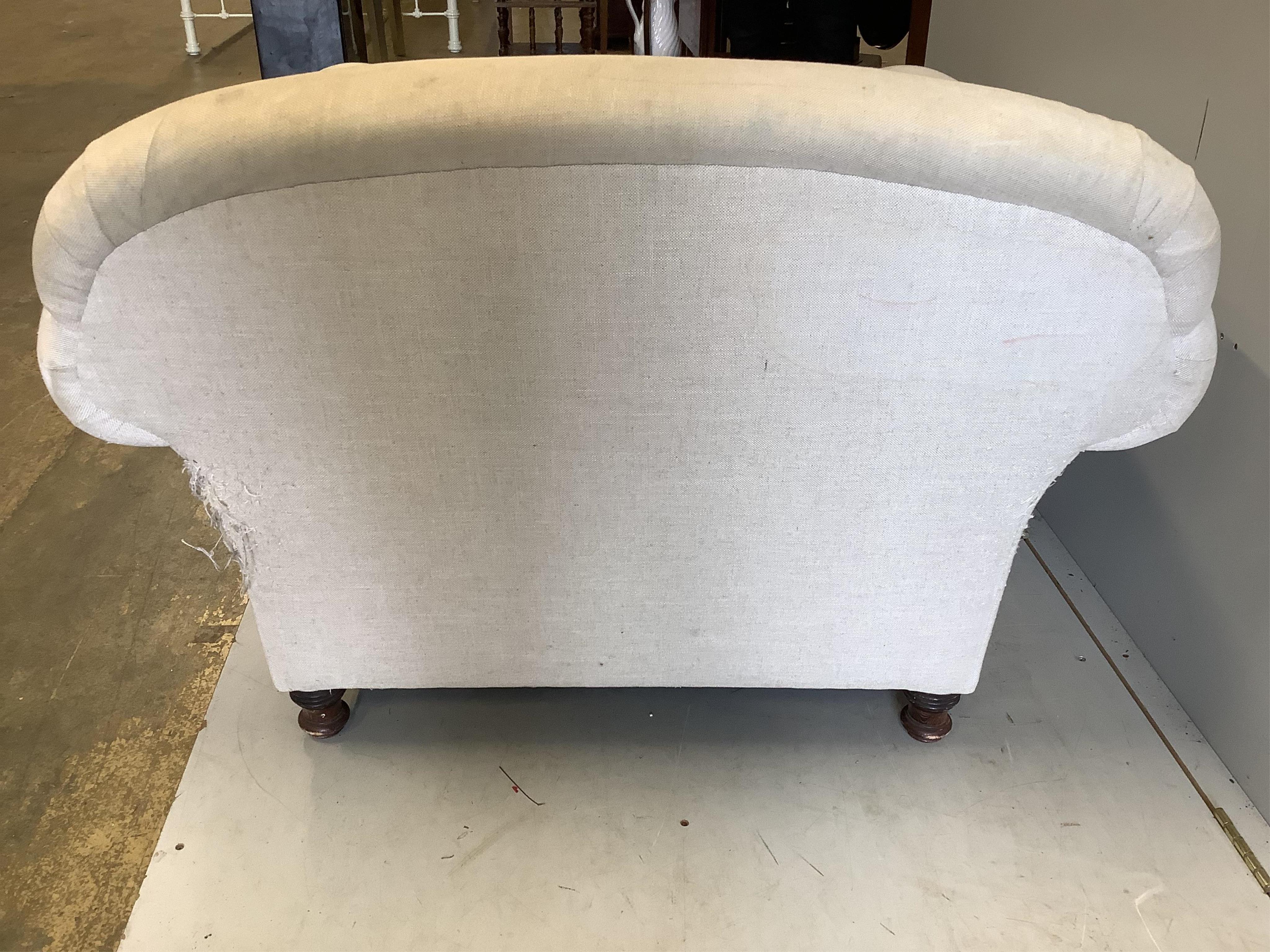 A Howard style upholstered armchair, width 115cm, depth 110cm, height 78cm. Condition - fair, upholstery scratched and requires cleaning